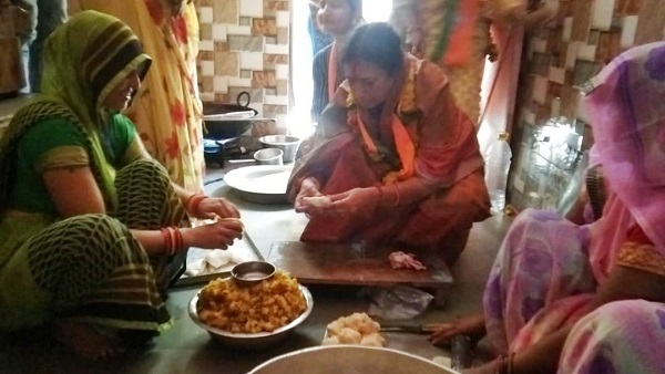 भाजपा प्रत्‍याशी मतदाता के घर समोसे बनवाते हुए 