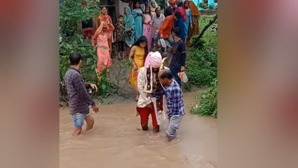 शेरवानी पहनकर बाढ़ के पानी में घुस गया दूल्हा