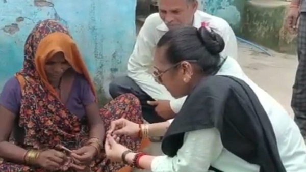 जेरठ गांव में एक घर के सामने बीड़ी बना रही थीं