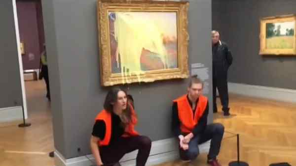 काले कपड़े और नारंगी रंग के जैकेट में विरोध