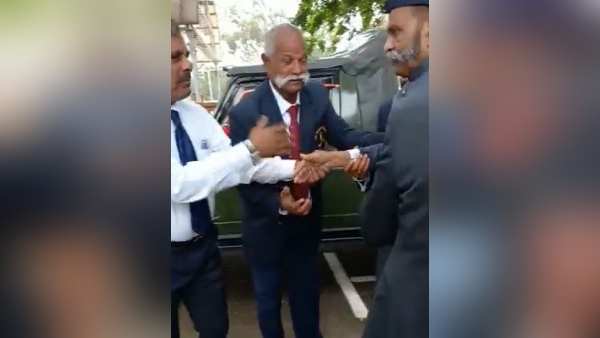 गोविंद स्वामी अधिकारियों से हाथ मिलाते हैं