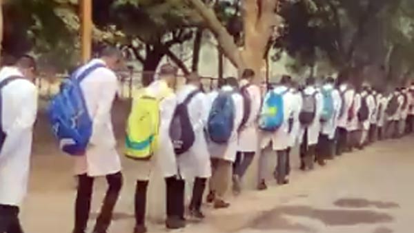 वायरल वीडियो में सिर झुका कर चल रहे छात्र 