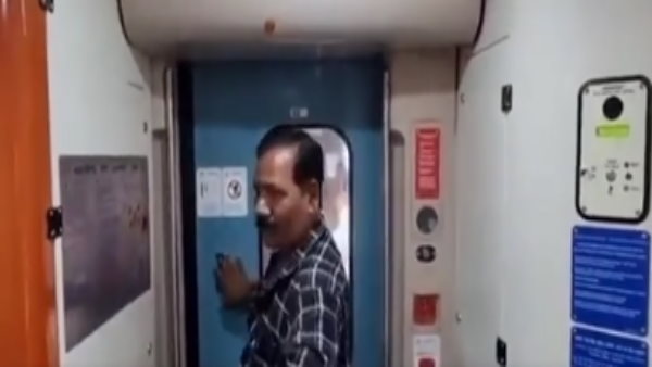 ट्रेन के डोर को अपने हाथ से खोलने लगा 