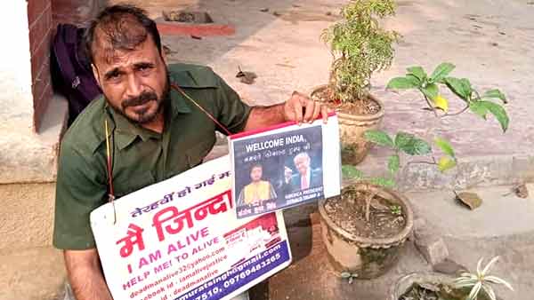 गले में 'मैं जिंदा हूं' का बोर्ड लटकाकर पहुंचा थाने
