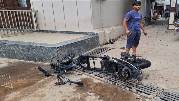 सड़क पर जल रही थी ई-स्कूटी, दशहत में दुकानें बंद कर भागे लोग सड़क पर जल रही थी ई-स्कूटी, दशहत में दुकानें बंद कर भागे लोग