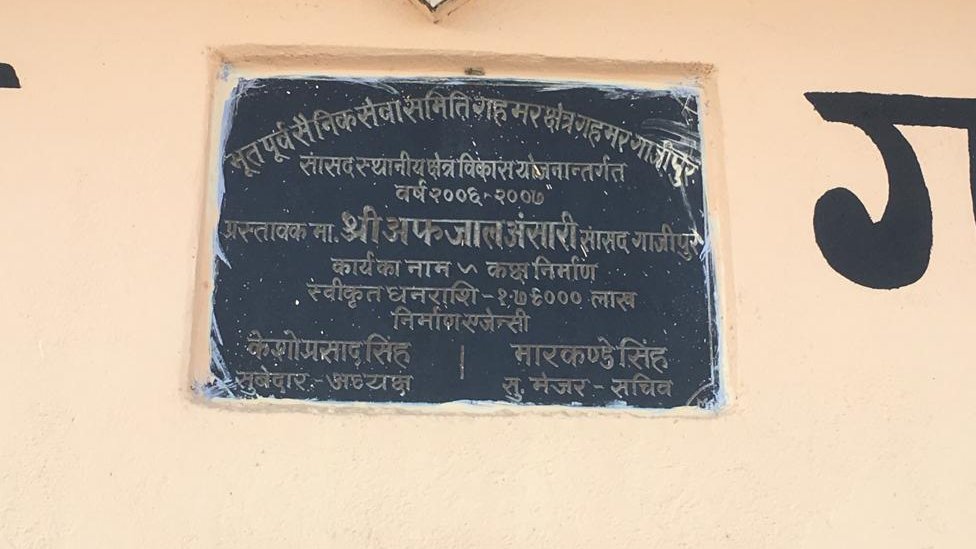 सांसद निधि खर्च से बनवाए गए भवन पर ग्रेनाइट पत्थर में लिखा हुआ सांसद का नाम