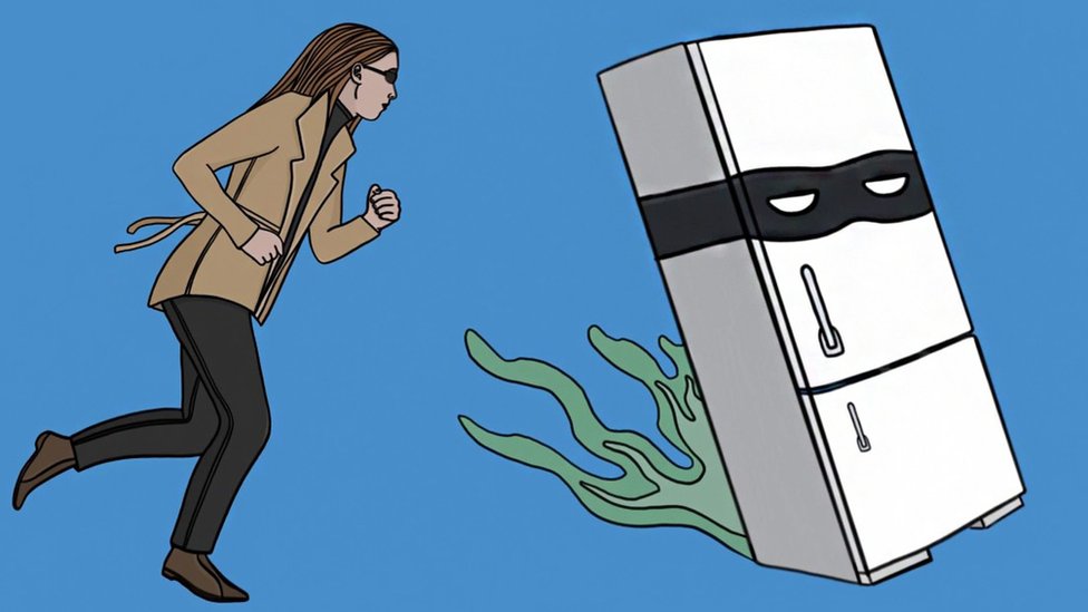 A woman chasing a fridge wearing a villains face