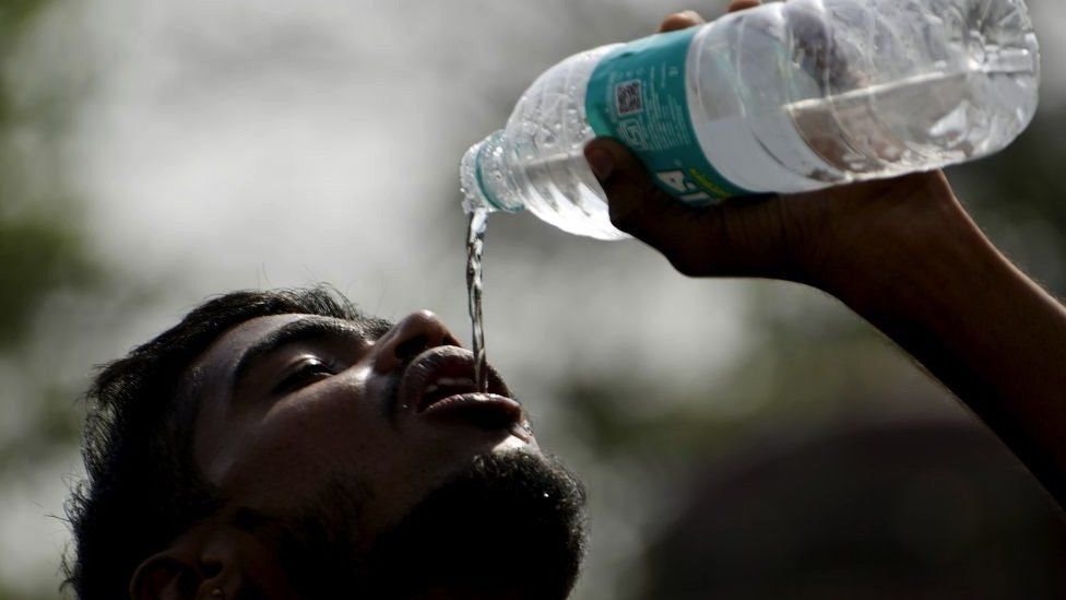 गर्मी के बीच ख़ुद को ठंडा रखने की कोशिश में एक युवक
