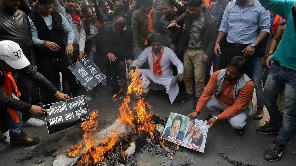 तस्वीरें जलाते लोग