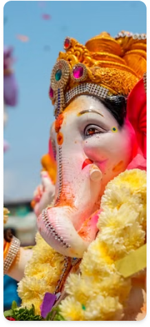 A vibrant Ganesh idol draped in marigold garlands