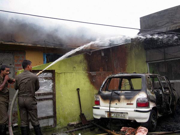 Army personnel douse fire at a house in Assam in July 2012 