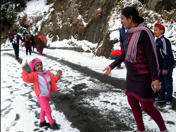 Family Fun: Kid, Mother enjoy snowfall