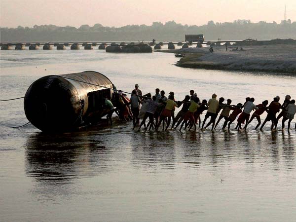Labourers work to construct a temporary pontoon bridge Labourers work to construct a temporary pontoon bridge