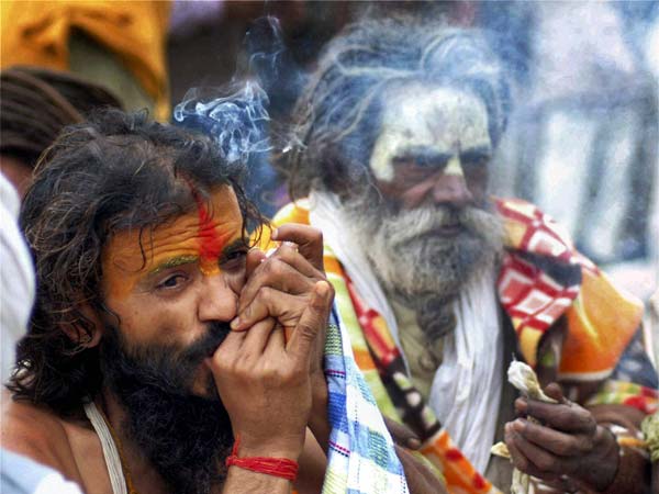 Naga sadhu smokes a chillum on a cold day Naga sadhu smokes a chillum on a cold day