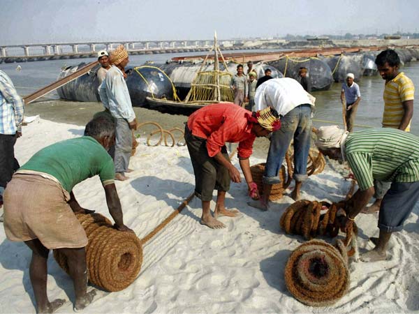 Labourers work to construct a temporary pontoon bridge Labourers work to construct a temporary pontoon bridge