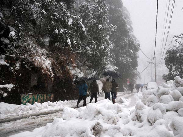 People walk at a snow-covered road 