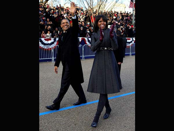 Barack Obama and Michelle Obama wave as they walk down Pennsylvania Avenue