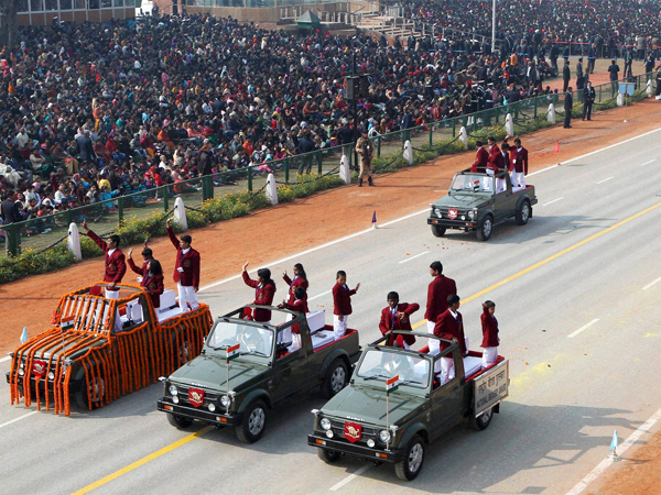 Brave children wave from open vehicles at Rajpath