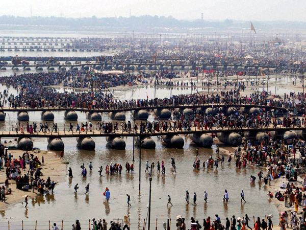 Thousands of devotees walk across a pontoon bridge