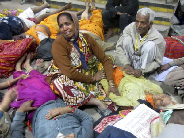 People weep next to the bodies of relatives