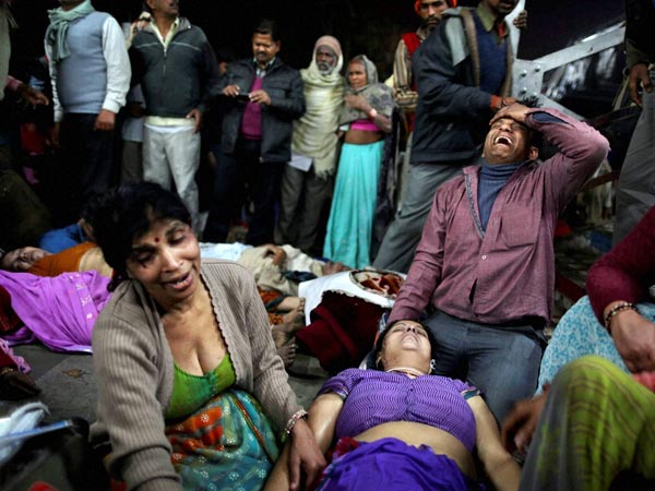 People weep next to the bodies of relatives