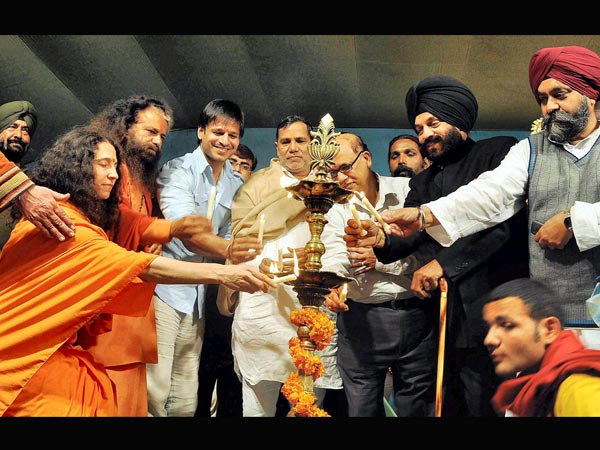 Actor Vivek Oberoi other devotees light a lamp during Maha Kumbh Mela