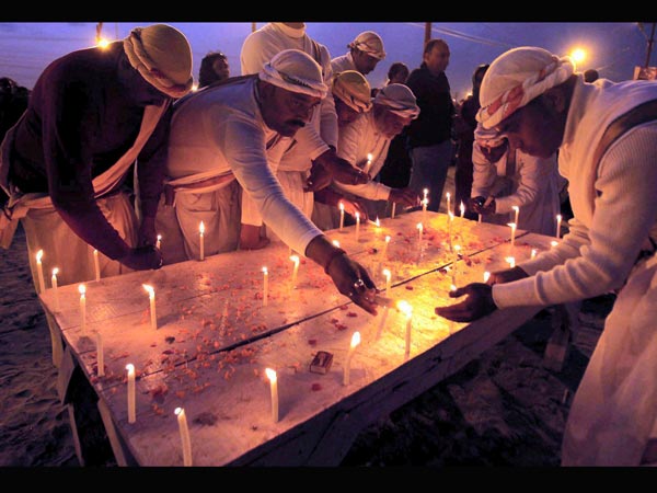 Priests light candles to pay homage