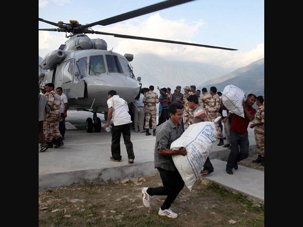 Indian Air Force personnel unloading relief material from a chopper