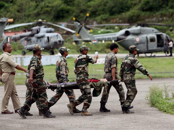 Army soldiers carry an injured rescued pilgrim