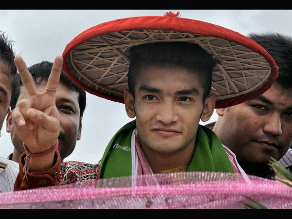 Shiva Thapa being felicitated with an Assamese Japi 