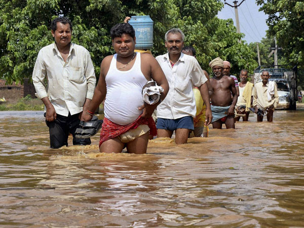People wade in flood-affected areas