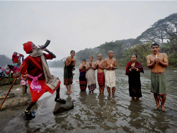 A sadhu blows a buffalo horn 