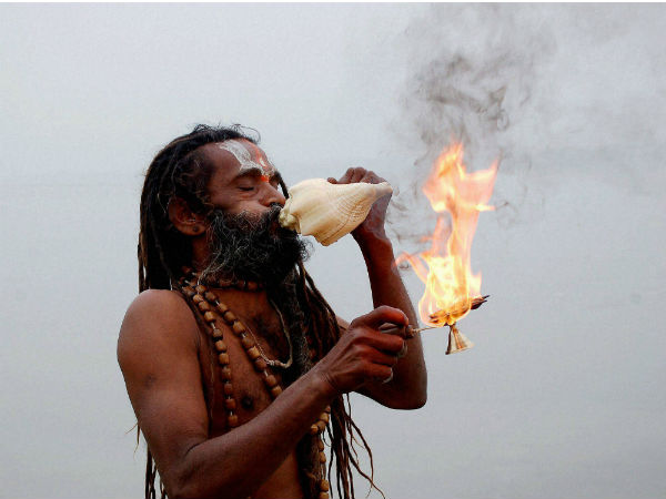 An sadhu performs arti after taking holy dip in river Ganga