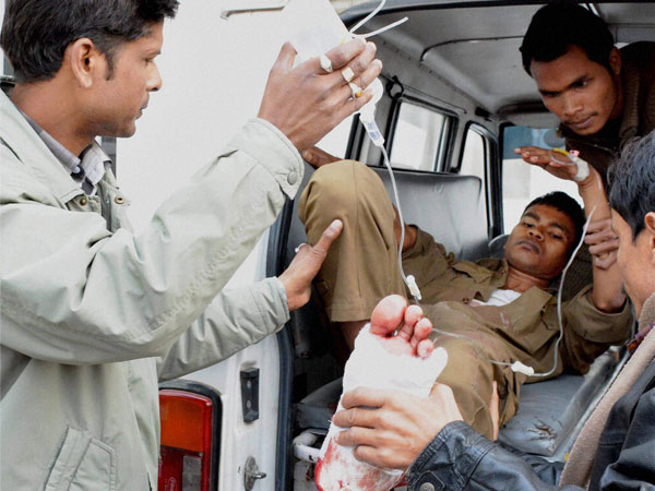 An injured police person is being brought to the Guwahati Medical College Hospital