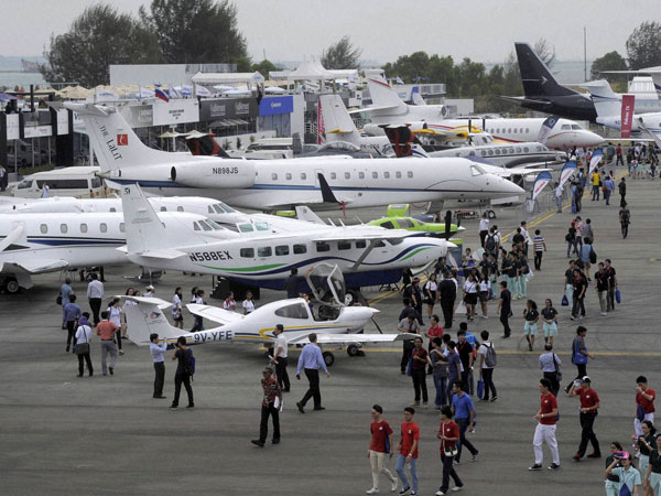 Visitors walk around commercial airplanes