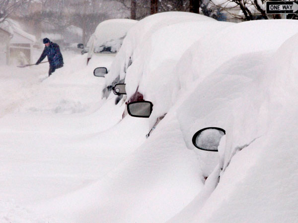 Snow covers a line of vehicles