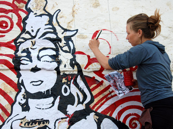 A foreign tourist gives final touches to a painting
