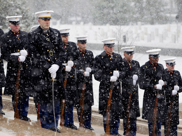 A US Marine Corps Honor Guard stand guard in the falling snow
