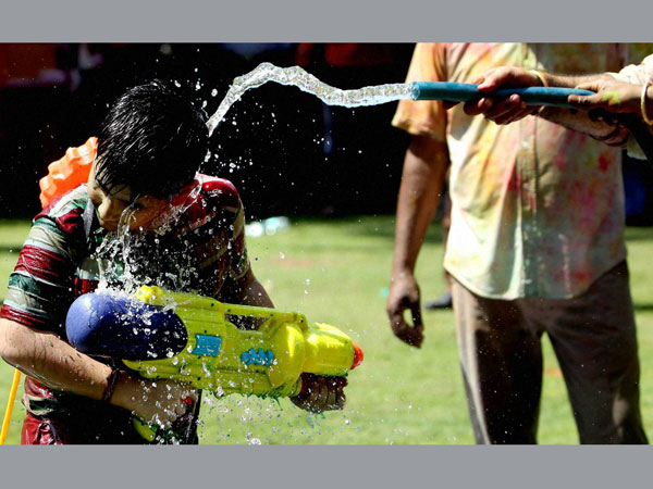 A boy play with water during Holi celebrations