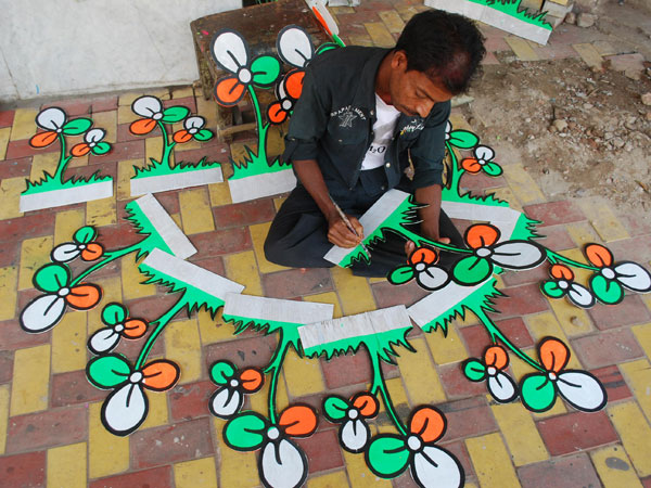 An artist gives final touches to a symbol of a political party