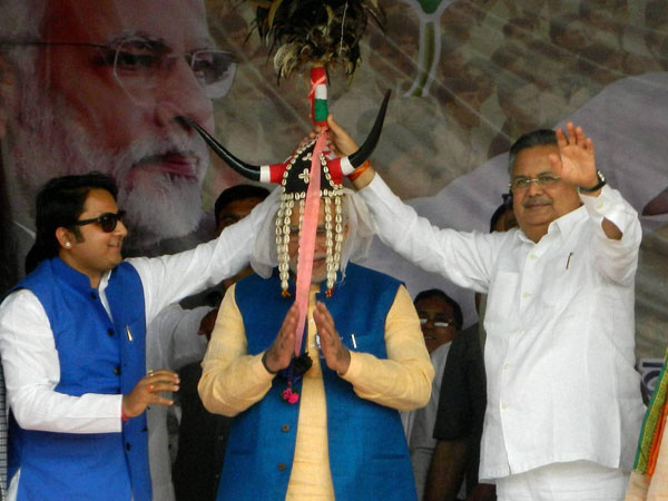 Narendra Modi wears a headgear presented by Chhattisgarh Chief Minister Raman Singh