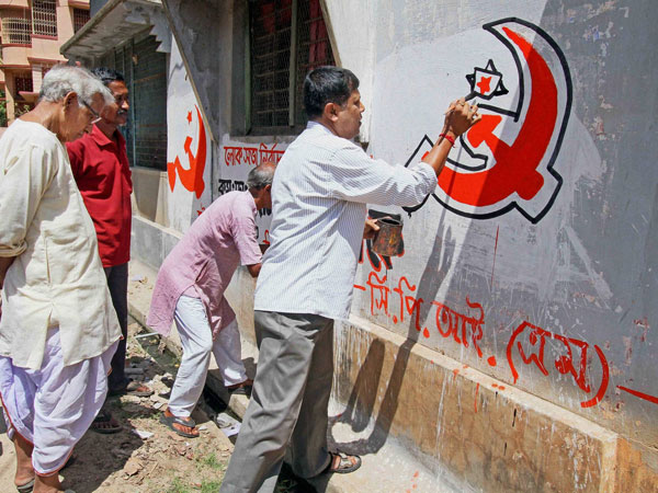 CPI(M) workers prepare party symbol on a wall