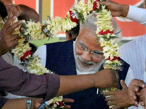 Narendra Modi is garlanded during an election rally