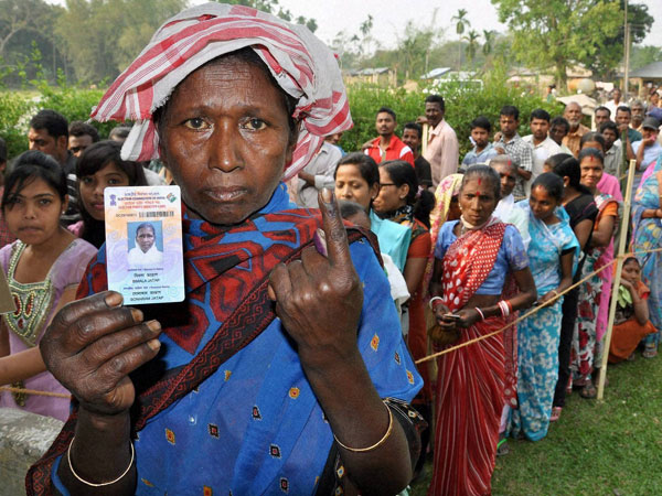 A woman shows her Voter ID card and her ink-marked finger A woman shows her Voter ID card and her ink-marked finger