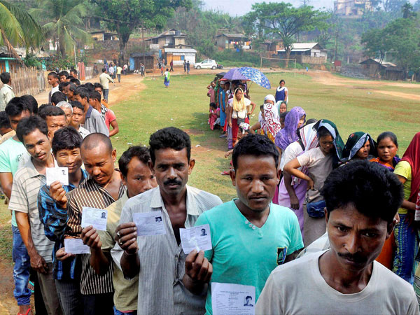 Voters queue to caste their vote in a polling station