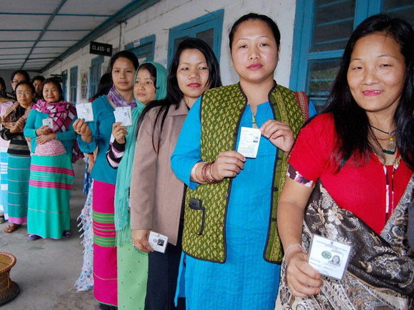 Voters stand in a queue to cast their votes