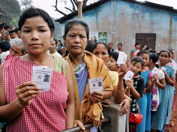 Voters stand in queue to cast their vote