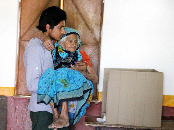 An elderly woam being carried at a polling station An elderly woam being carried at a polling station