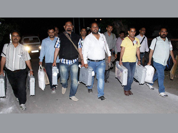 Polling officials carry electronic voting machines (EVM) Polling officials carry electronic voting machines (EVM)