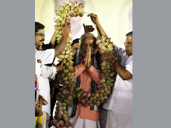 Narendra Modi being garlanded at an election rally